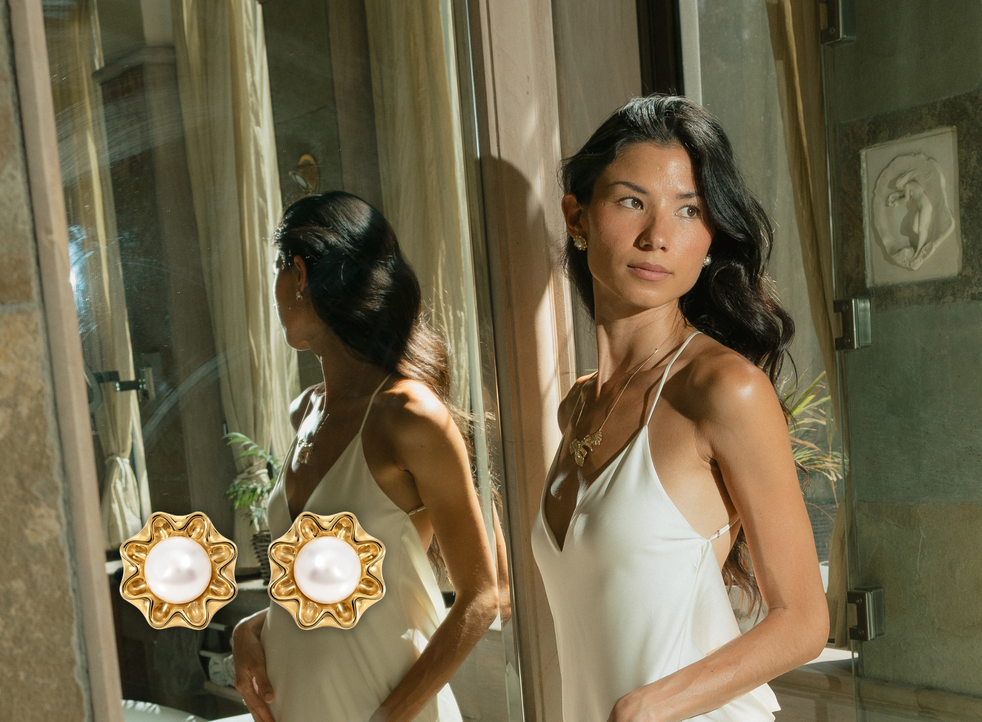 Woman wearing gold pearl earrings and necklace in soft natural light, fine jewellery handcrafted in London